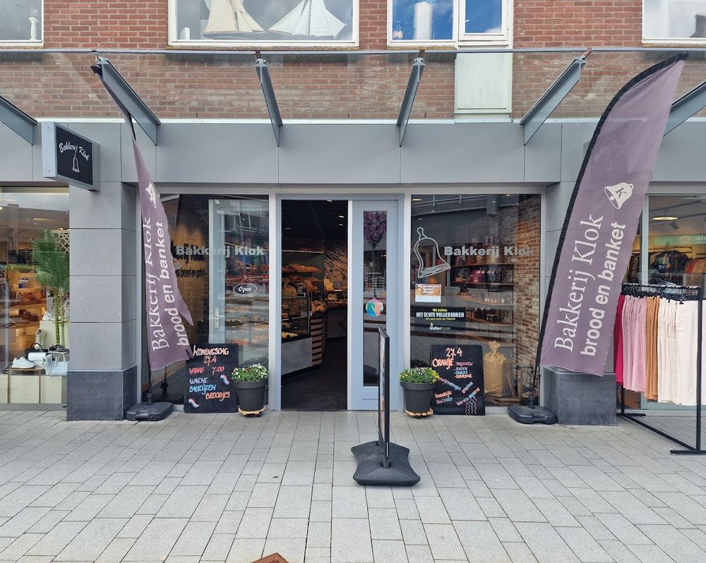 De voorkant van Bakkerij Klok met de paarse vlaggen